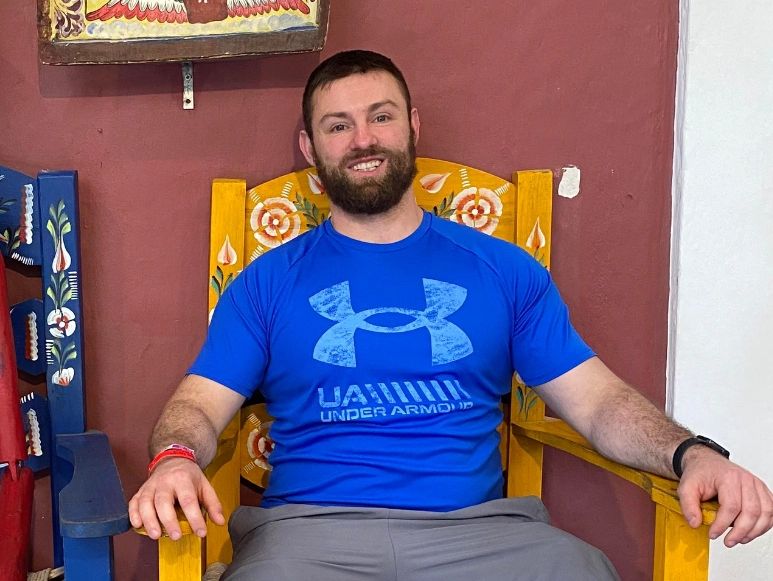 Tom seated in a colorful chair